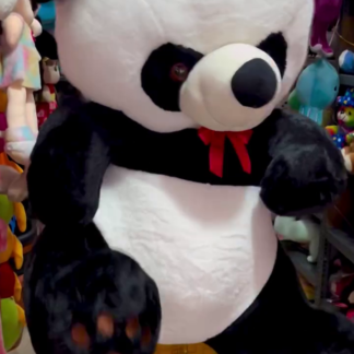 Giant panda plush toy with red bow