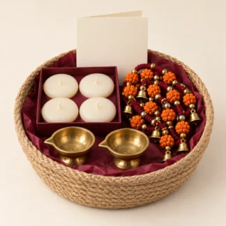 Jute gift basket with two brass diyas, floating candles, a beaded toran and a blank greeting card